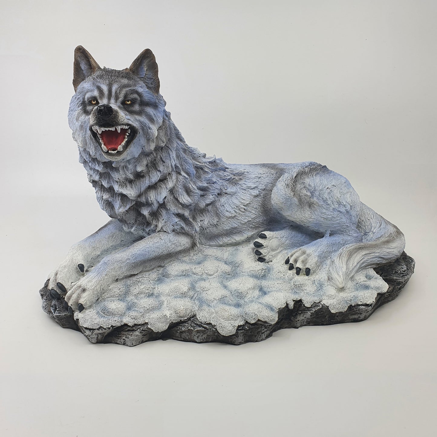 Lupo delle nevi seduto su base 36cm